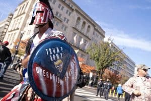 A demonstrator holds a "Trump Army, Operation Flag Drop" shield in Black Lives Matter plaza near the White House in Washington, D.C., U.S., on Friday, Nov. 13, 2020. The Trump administration is stepping back from negotiations on a new stimulus package and leaving it to Senate Majority Leader&nbsp;McConnell&nbsp;to revive long-stalled talks with House Speaker Pelosi, according to two people familiar with the matter. Photographer: Stefani Reynolds/Bloomberg via Getty Images (Bloomberg/Getty Images)